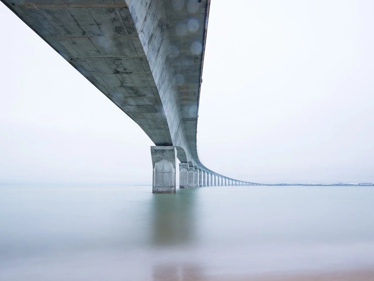 A long concrete bridge over calm water